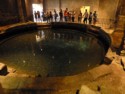 People throw coins in the circular bath